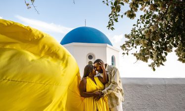 couple with yellow flying dress photography in Santorini